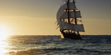 sailing ship emerging from ocean